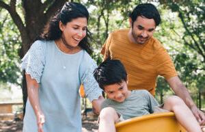 parents pushing a kid in a swing